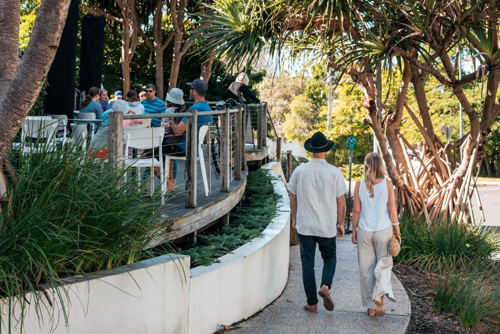 couple walking past sunshine beach restaurants